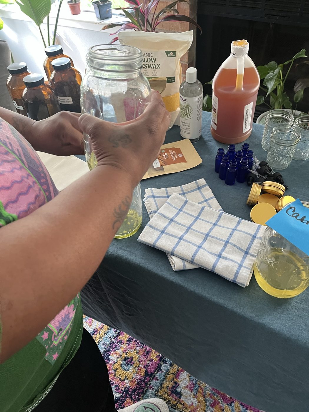 Hands packing a jar with cinnamon and oil