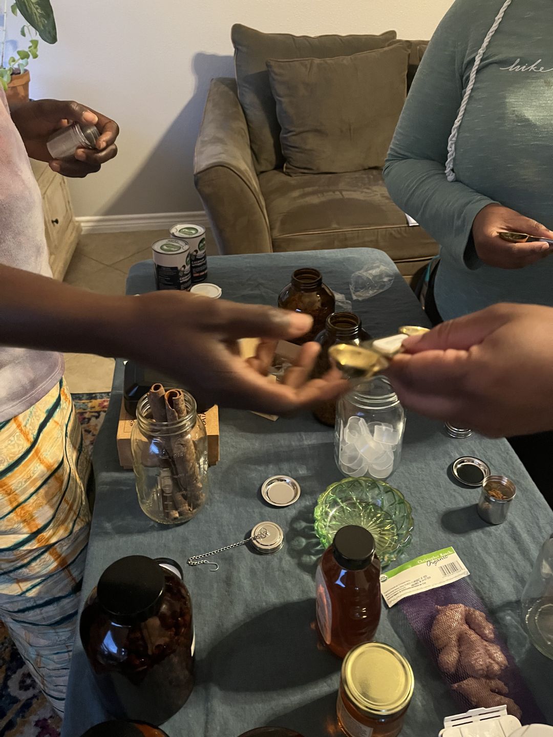 Hands pouring warm oil into salve tins