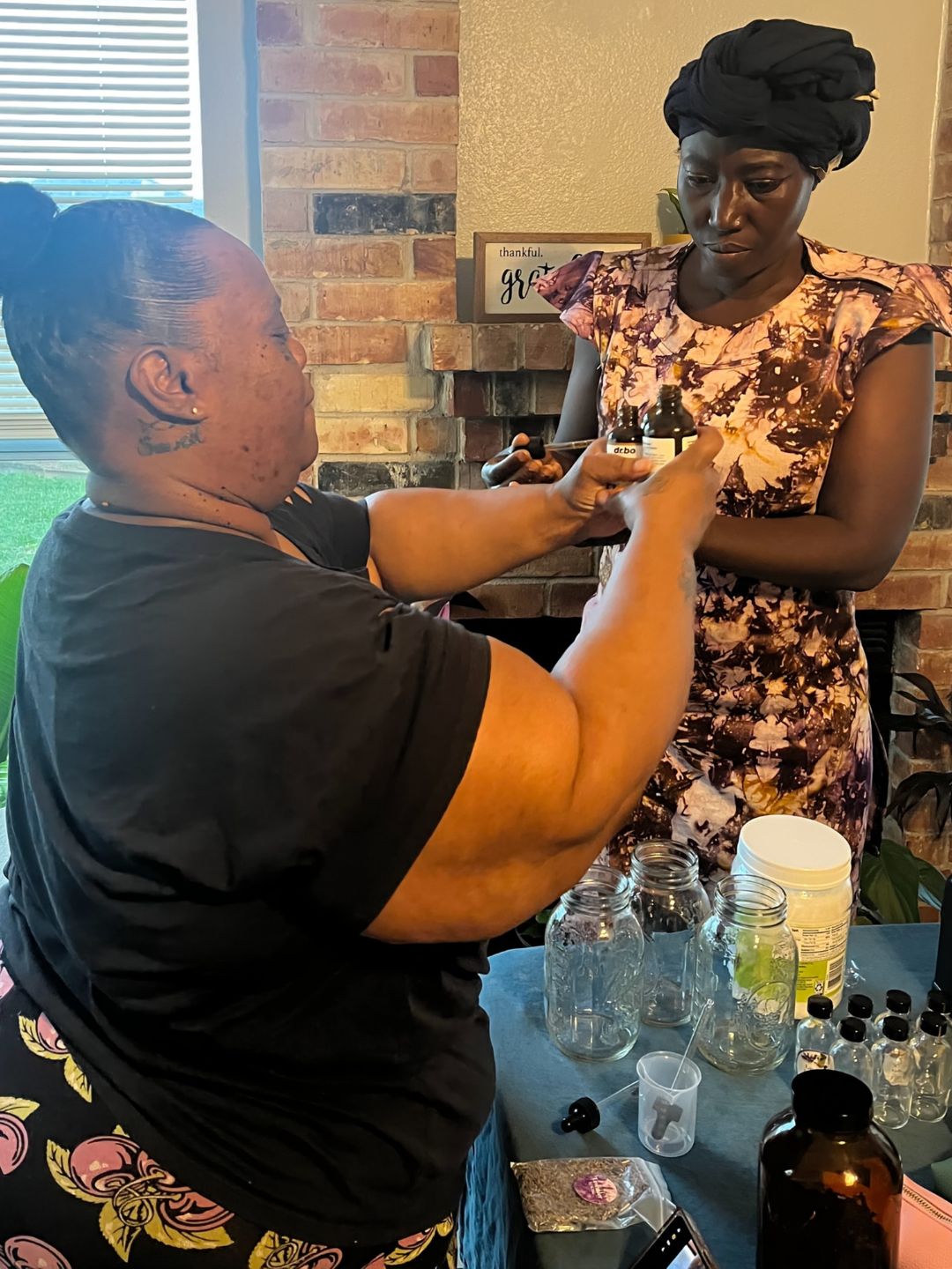 Hands at work measuring herbs into a salve base